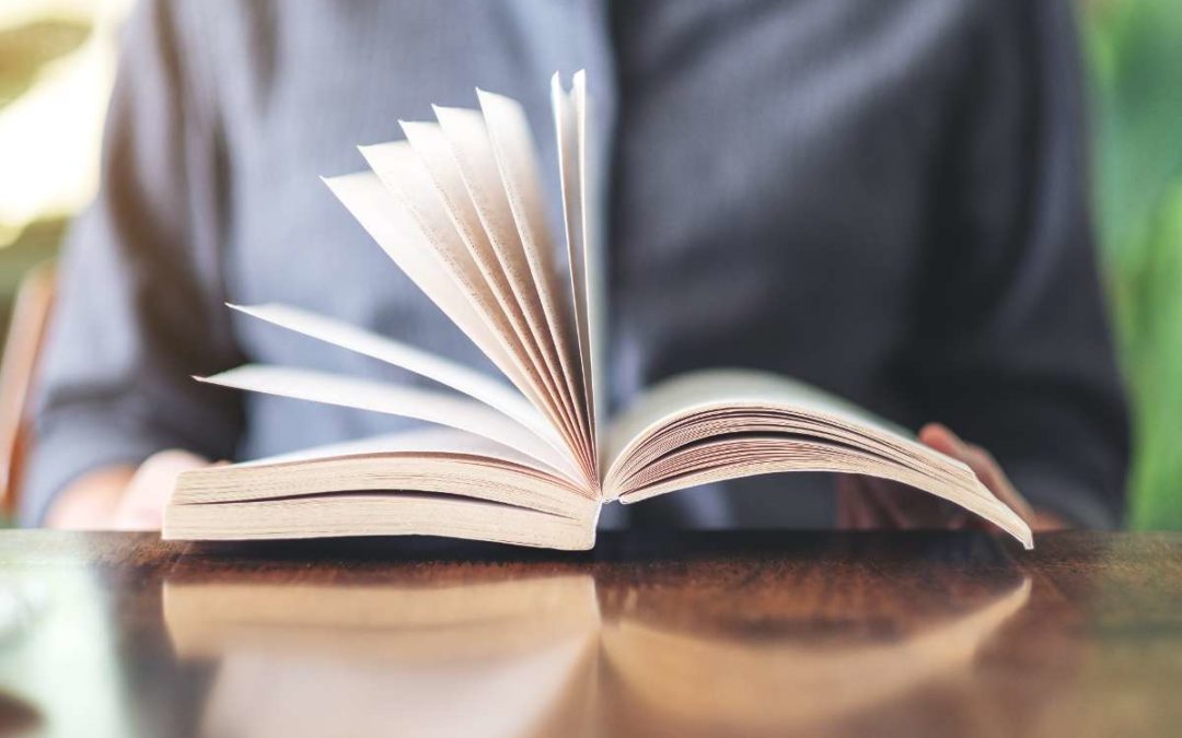 Stack of recommended personal finance books placed on a wooden desk with a coffee cup, symbolizing education and financial literacy.